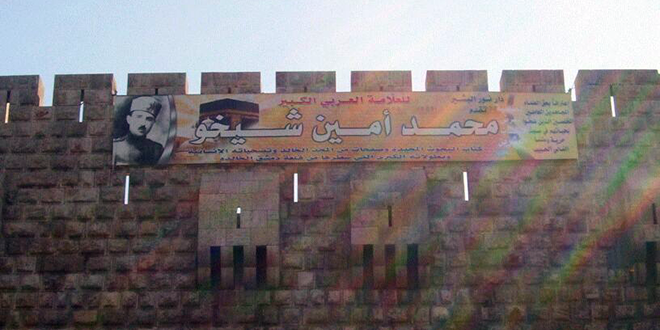 صورة العلامة الإنساني محمد أمين شيخو معلقة على قلعة دمشق